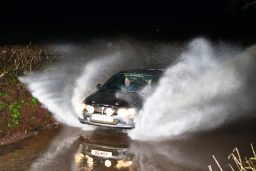 Road rally car going through water splash