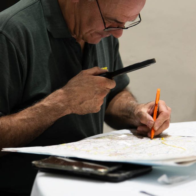 Navigator plotting a rally route on OS map